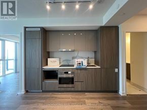 Vaughan (Vaughan Corporate Centre) condo for rent - A modern kitchen with wooden cabinets and a built-in oven.