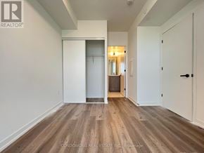 Vaughan (Vaughan Corporate Centre) condo for rent - A room with wood flooring and white walls, with a door on the right and a window on the left.
