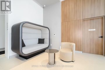 Burlington (Brant) condo for rent - A modern living room with a white sofa and a wooden cabinet.
