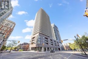 Burlington (Brant) condo for rent - A modern building with a curved facade is the focal point of the image.