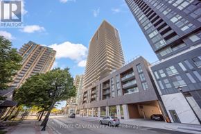 Burlington (Brant) condo for rent - A modern building with a curved facade stands in front of other buildings.