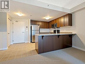 Guelph (Pineridge/Westminster Woods) condo for rent - A kitchen with brown cabinets and a white fridge.