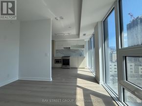 Toronto (Church-Yonge Corridor) condo for rent - A spacious room with a view of the city through large windows.