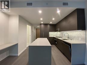 Burnaby apartment for rent - A modern kitchen with dark brown cabinets and a white countertop.
