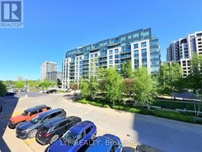 Markham (Unionville) condo for rent - A parking lot with several cars and a building in the background.