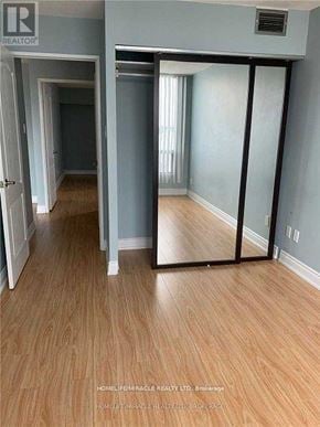 Mississauga (Cooksville) condo for rent - A room with wooden flooring and a sliding door.
