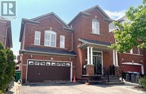 Brampton (Bram East) apartment for rent - A red brick house with a garage door that has a pattern on it.