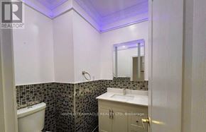 Brampton (Bram East) apartment for rent - A bathroom with a white tub, sink, and tiled walls.