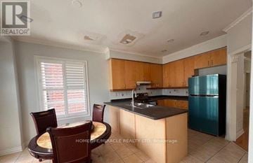 Brampton (Bram East) apartment for rent - A kitchen with wooden cabinets and a blue refrigerator.