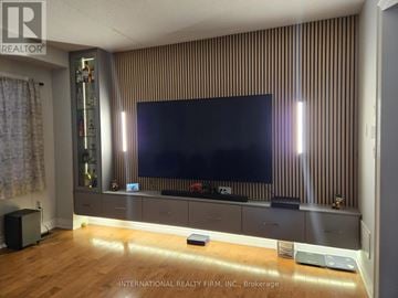 Brampton (Credit Valley) apartment for rent - A modern living room with a large flat screen TV mounted on a striped wall.