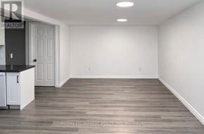 Brantford apartment for rent - A room with a wooden floor and white walls.