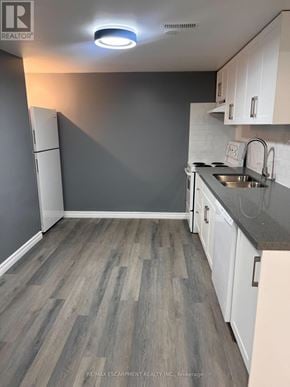 Brantford apartment for rent - A kitchen with white cabinets and a grey floor.
