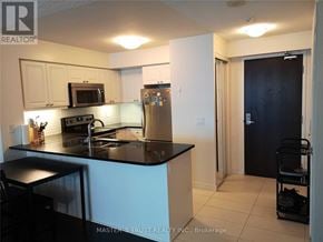 Toronto (Waterfront Communities) condo for rent - A kitchen with a black counter top and stainless steel appliances.