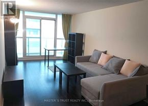 Toronto (Waterfront Communities) condo for rent - A living room with a grey couch and a black coffee table.