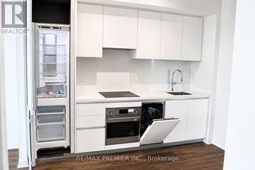 Mississauga (City Centre) condo for rent - A white kitchen with a refrigerator and sink.