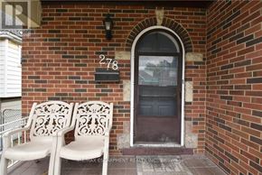 Hamilton (Delta) apartment for rent - Two white chairs are placed on a porch in front of a brick wall.
