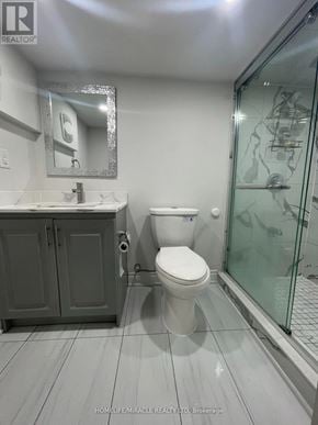 Brampton (Northwest Brampton) apartment for rent - A white toilet in a bathroom with a glass shower door.