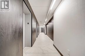 Toronto (Church-Yonge Corridor) condo for rent - A long hallway with a wood grain wall on the left and a white wall on the right.