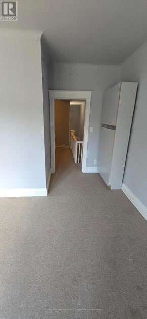 Toronto (Roncesvalles) apartment for rent - A room with a carpeted floor and a doorway leading to another room.