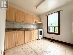 Toronto (South Riverdale) townhouse for rent - A kitchen with wooden cabinets and a tiled backsplash.