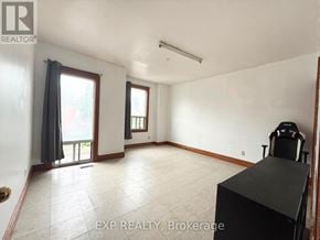 Toronto (South Riverdale) townhouse for rent - A room with a black desk and a window with curtains.