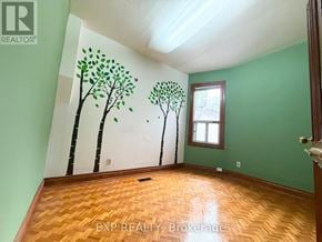 Toronto (South Riverdale) townhouse for rent - A room with a green wall and a tree mural on the wall.