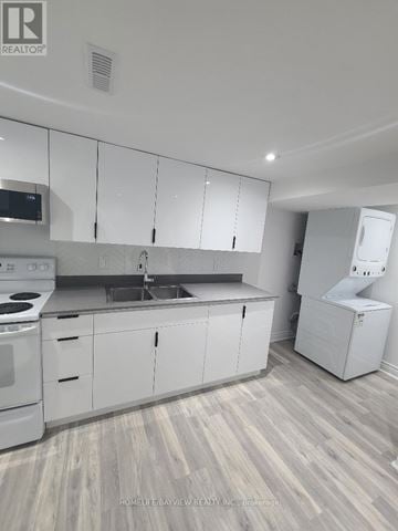 Vaughan (Brownridge) apartment for rent - A kitchen with white cabinets and a wooden floor.