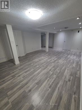 Vaughan (Brownridge) apartment for rent - A spacious room with wooden flooring and white walls.