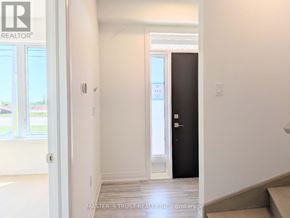 Richmond Hill townhouse for rent - A hallway with a black door and a window with a view of a parking lot.