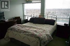 Toronto (Bayview Village) condo for rent - A bedroom with a bed, desk, and window overlooking the ocean.