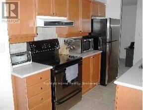 Toronto (Bayview Village) condo for rent - A kitchen with wooden cabinets and black appliances.