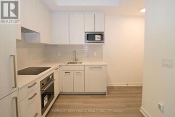 Toronto (Parkwoods-Donalda) townhouse for rent - A kitchen with white cabinets and a microwave above the stove.