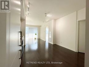Toronto (Moss Park) condo for rent - A spacious room with a long hallway and a kitchen area with stainless steel appliances.