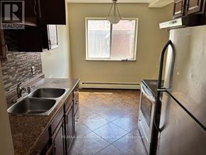 Hamilton (Glenview) multi-family for rent - A kitchen with a sink, stove, and refrigerator.