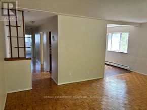 Hamilton (Glenview) multi-family for rent - A room with wooden flooring and white walls, with a window on the right side.