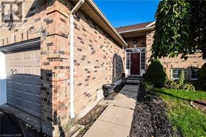 Beamsville apartment for rent - A brick house with a garage door and a door with a window.