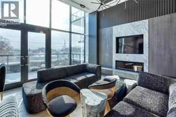 Burlington condo for rent - A living room with a grey couch and a fireplace.
