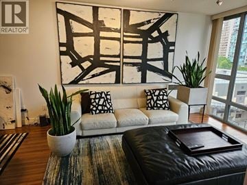 Vancouver apartment for rent - A living room with a white couch, a large abstract painting, and a coffee table with a tray on it.
