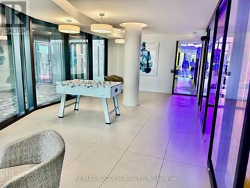 Burlington (Alton) condo for rent - A modern living room with a white sofa and a glass table.