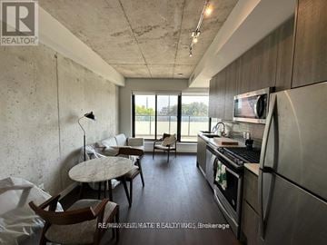 Toronto (South Riverdale) condo for rent - A kitchen with a table and chairs in front of a window.