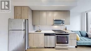 Toronto (Waterfront Communities) condo for rent - A modern kitchen with a refrigerator, microwave, oven, and sink.