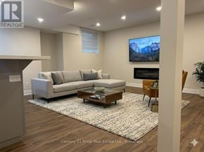 Oakville (Ro River Oaks) apartment for rent - A living room with a grey sofa and a coffee table in front of a television.