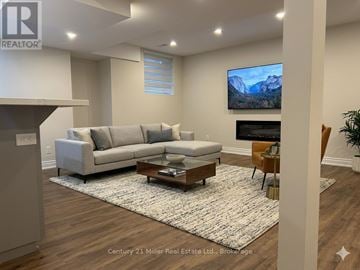 Oakville (Ro River Oaks) apartment for rent - A living room with a grey sofa and a coffee table in front of a television.