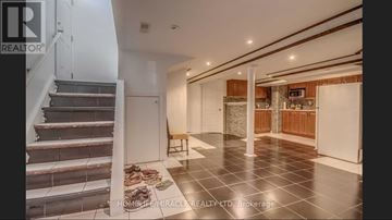 Toronto (Woburn) apartment for rent - A spacious hallway with a staircase and a kitchen area.
