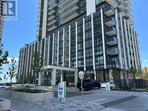 Vaughan (Vellore Village) condo for rent - A modern building with a glass facade and a black car parked in front.