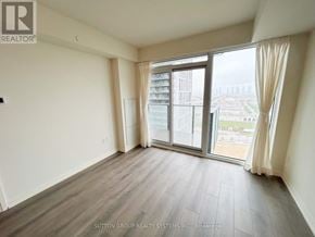Vaughan (Vellore Village) condo for rent - A room with a view of a cityscape through large windows.
