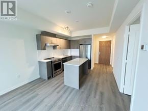 Vaughan (Vellore Village) condo for rent - A modern kitchen with a white island and stainless steel appliances.