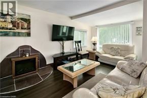 Wasaga Beach apartment for rent - A living room with a television, a fireplace, and a couch.