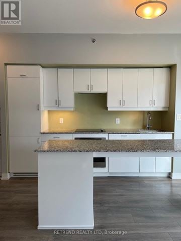 Toronto (Kensington-Chinatown) condo for rent - A kitchen with white cabinets and a granite countertop.
