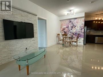 Vaughan (Beverley Glen) condo for rent - A modern living room with a glass coffee table and a flat screen TV mounted on a brick wall.